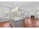 Open kitchen with large central island, granite countertops, and stainless steel appliances overlooking the living area at 376 Delburg St, Davidson, NC 28036