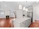 Spacious kitchen with island, granite countertops, stainless appliances, and connected living area with fireplace at 376 Delburg St, Davidson, NC 28036
