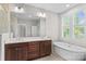 Main bathroom with double sink vanity, soaking tub, and large mirror with great lighting at 376 Delburg St, Davidson, NC 28036