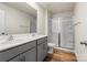 Bathroom with a double sink vanity, glass shower and wood-look floors at 4116 Lurelin Ln, Charlotte, NC 28262