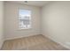 An empty bedroom featuring neutral paint, carpet, and a window with blinds at 4116 Lurelin Ln, Charlotte, NC 28262