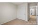 Cozy bedroom featuring neutral carpeting and a white door to the hallway and laundry room at 4116 Lurelin Ln, Charlotte, NC 28262