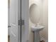 Contemporary powder room featuring a pedestal sink, oval mirror, and neutral paint at 4116 Lurelin Ln, Charlotte, NC 28262