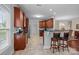 Well-lit kitchen with wooden cabinets, granite countertops, breakfast bar, and tile floor at 422 Drake Ln, Salisbury, NC 28146
