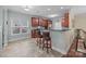 Kitchen featuring wooden cabinets, granite counters, breakfast bar with seating, and tile flooring at 422 Drake Ln, Salisbury, NC 28146