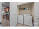 Laundry room featuring white washer and dryer, storage shelf, and tile flooring at 422 Drake Ln, Salisbury, NC 28146