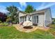 Landscaped backyard featuring a stone patio, outdoor seating, lush greenery, and mature trees for privacy at 43041 Mimosa Ct, Fort Mill, SC 29707