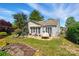 Spacious backyard with stone patio, outdoor seating, lush landscaping, and mature trees creating a private oasis at 43041 Mimosa Ct, Fort Mill, SC 29707