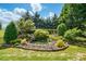 Backyard landscape showcasing a tiered water feature surrounded by lush greenery and stone accents at 43041 Mimosa Ct, Fort Mill, SC 29707