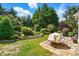 Serene backyard featuring lush landscaping, a stone patio, and a tranquil water feature at 43041 Mimosa Ct, Fort Mill, SC 29707