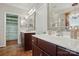 Bathroom showcasing a double vanity, decorative mirrors, and a walk-in closet with custom shelving at 43041 Mimosa Ct, Fort Mill, SC 29707