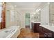 Bright bathroom featuring a soaking tub, glass shower, double vanity, and a walk-in closet at 43041 Mimosa Ct, Fort Mill, SC 29707