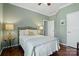 Comfortable bedroom featuring hardwood floors, crown molding, and lamps on a side table at 43041 Mimosa Ct, Fort Mill, SC 29707