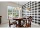 Charming dining area featuring a wooden table, chairs, modern light fixture, and a distinctive buffalo check accent wall at 43041 Mimosa Ct, Fort Mill, SC 29707
