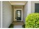 Covered entryway showcasing a modern glass front door, lush landscaping, and neutral siding at 43041 Mimosa Ct, Fort Mill, SC 29707