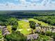 Aerial view of a lush golf course community with pristine greens, sand traps, and beautiful homes nestled amidst trees at 43041 Mimosa Ct, Fort Mill, SC 29707