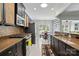 Well-lit kitchen featuring granite countertops, stainless steel appliances, and stylish black and wicker cabinets at 43041 Mimosa Ct, Fort Mill, SC 29707