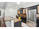 Bright kitchen showcasing stainless steel appliances, granite countertops, and sleek black cabinets with wicker accents at 43041 Mimosa Ct, Fort Mill, SC 29707