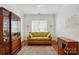 Elegant living room featuring hardwood floors, a display cabinet, and a modern sofa with decorative pillows at 43041 Mimosa Ct, Fort Mill, SC 29707
