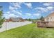 Spacious backyard with a well-manicured lawn, white fence, and a charming wooden deck at 4406 Atkinson Way, Monroe, NC 28110
