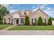 Well-maintained brick home features manicured lawn, mature trees, and inviting front porch for curb appeal at 4406 Atkinson Way, Monroe, NC 28110