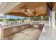 Outdoor kitchen features stone accents, a built-in grill, sink, and ceiling fans at 4406 Atkinson Way, Monroe, NC 28110