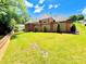 Expansive backyard showcasing lush lawn, privacy landscaping, and brick exterior of the home at 456 Brook Valley Ne Ct, Concord, NC 28025