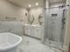 Modern bathroom featuring marble floors, marble shower, a free-standing soaking tub, and dual vanities with round mirrors at 456 Brook Valley Ne Ct, Concord, NC 28025
