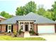 Charming brick home featuring a well-manicured lawn, complemented by a two car garage and a stylish, columned entryway at 456 Brook Valley Ne Ct, Concord, NC 28025