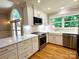 Modern, all-white kitchen with stainless steel appliances, quartz countertops, and stylish lighting, and hardwood floors at 456 Brook Valley Ne Ct, Concord, NC 28025
