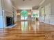Bright, open-concept living room featuring gleaming hardwood floors, fireplace, large window, and view into the updated kitchen at 456 Brook Valley Ne Ct, Concord, NC 28025