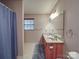 Traditional bathroom featuring a double sink vanity, a shower with a curtain, and wallpaper at 4620 Binwhe Ln, Gastonia, NC 28052