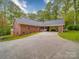 Side angle of a single-story brick home showing the long driveway, lawn, and carport at 4620 Binwhe Ln, Gastonia, NC 28052