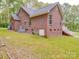 Back angle of a single-story brick home with a green lawn, white stairs, and foliage at 4620 Binwhe Ln, Gastonia, NC 28052