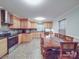 Bright kitchen with stainless steel appliances, wood cabinets, and an oversized wooden dining table at 4620 Binwhe Ln, Gastonia, NC 28052
