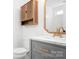 Bathroom with a marble countertop vanity, wood storage cabinet, and a decorative gold mirror at 4719 Sahalee Ln, Charlotte, NC 28216