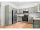 Bright kitchen featuring gray cabinets, stainless steel appliances, and hardwood floors at 4719 Sahalee Ln, Charlotte, NC 28216