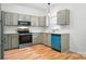 Modern kitchen featuring gray cabinets, stainless steel appliances, and hardwood floors at 4719 Sahalee Ln, Charlotte, NC 28216