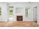 Bright living room with a fireplace and natural light from the windows and glass paneled door at 4719 Sahalee Ln, Charlotte, NC 28216