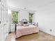 Simple bedroom with hardwood floors, neutral color palette and natural light from two windows at 4846 Deer Cross Trl, Charlotte, NC 28269