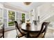 Elegant dining area with a large window featuring plantation shutters, a round table, and a decorative chandelier at 4846 Deer Cross Trl, Charlotte, NC 28269