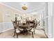 Elegant dining area featuring a large mirror, round table, and stylish chandelier, with views of the home's staircase at 4846 Deer Cross Trl, Charlotte, NC 28269
