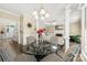 Inviting dining area with black and white patterned chairs and a black glass table, flowing into the living room at 4846 Deer Cross Trl, Charlotte, NC 28269