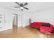 Bright living room featuring hardwood floors, a ceiling fan and a red sofa with chaise lounge at 4846 Deer Cross Trl, Charlotte, NC 28269