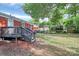 The backyard shows a wooden deck attached to the house, with mature trees in the background at 4913 Winchester St, Charlotte, NC 28208