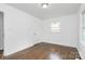 An airy bedroom features wood floors and a large window for lots of light at 4913 Winchester St, Charlotte, NC 28208