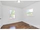 A well lit bedroom with hardwood floors, white trim, and a large window at 4913 Winchester St, Charlotte, NC 28208