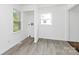 Bright laundry room featuring light gray wood-look floors and two windows for natural light at 4913 Winchester St, Charlotte, NC 28208