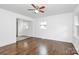 Spacious living room with gleaming hardwood floors, a ceiling fan, and large windows at 4913 Winchester St, Charlotte, NC 28208