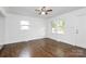 Bright living room with gleaming hardwood floors, a ceiling fan, and large windows at 4913 Winchester St, Charlotte, NC 28208